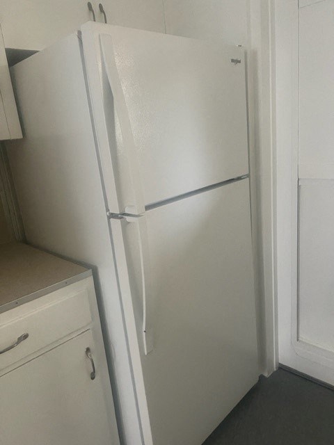 a white refrigerator freezer sitting next to a window
